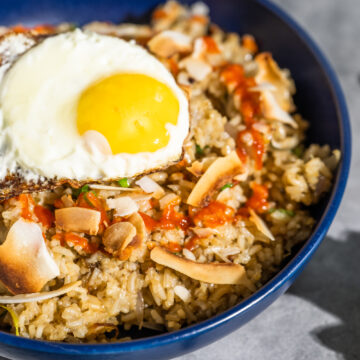 Ginger & Mary Jane Fried Rice topped with sriracha and a fried egg
